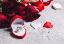 Geometric Rings: Modern Jewelry for Minimalist Style A diamond ring in a red heart-shaped box placed beside red roses and decorative heart shapes on a textured surface, styled as a romantic jewelry display.